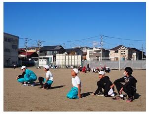 ６年生が座って放送を聞いています