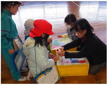 丁寧に１年生にゲームのやり方を伝えている２年生